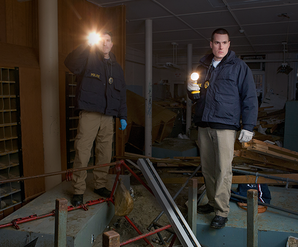 Two US Postal Inspectors shining flashlights